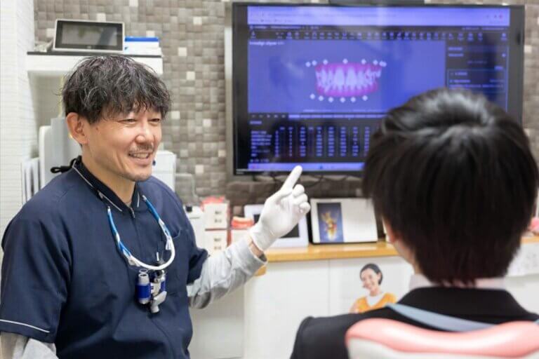 モニターで説明する理事長